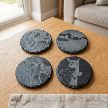 Four photo-engraved slate coasters on an oak table