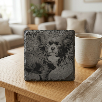 Square slate coaster engraved with a dog portrait on an oak coffee table