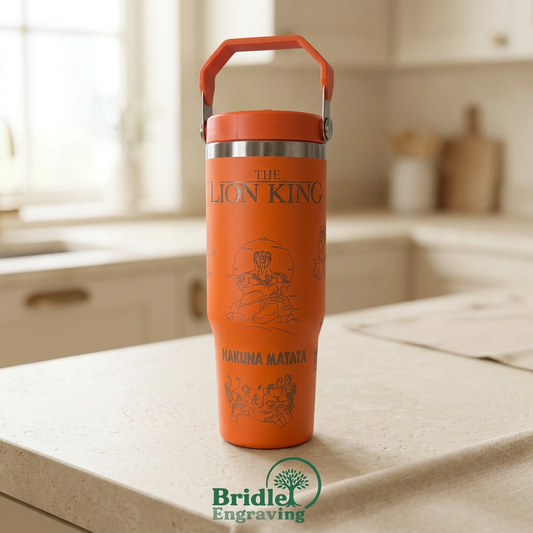 Orange engraved drinks bottle, front view, with warm kitchen background and Bridle Engraving logo